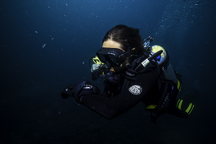 a single diver with a compass navigating underwater and in low visibility